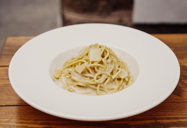 Un plato de pasta con una salsa blanca encima.