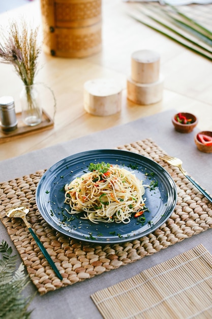 Foto un plato de pasta con tenedor y cuchara sobre una mesa.