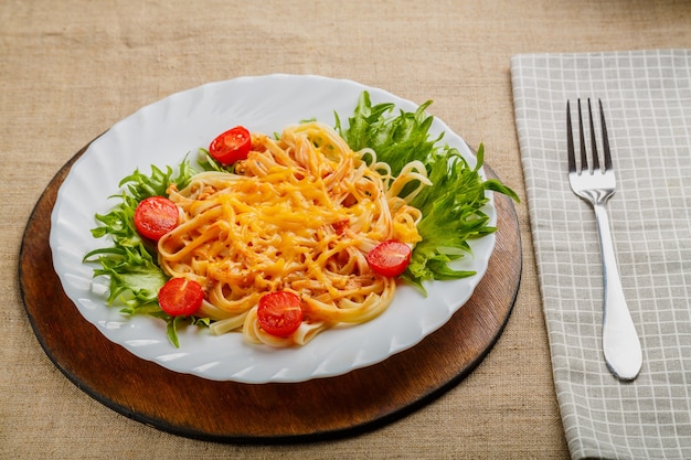 Un plato de pasta con tomates cherry y queso.