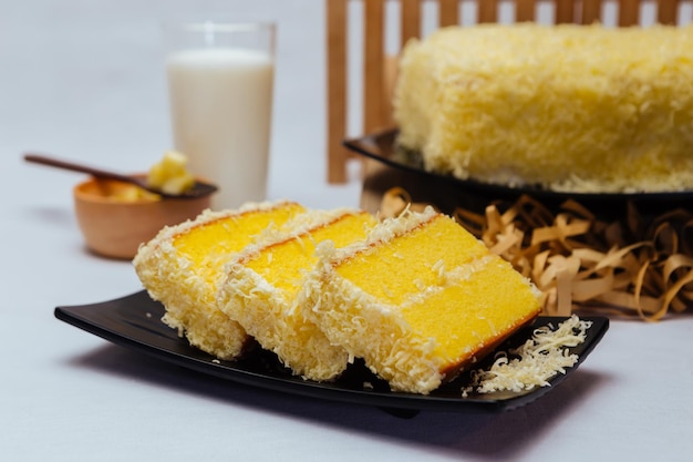 Un plato de pastel de limón con un vaso de leche al lado.