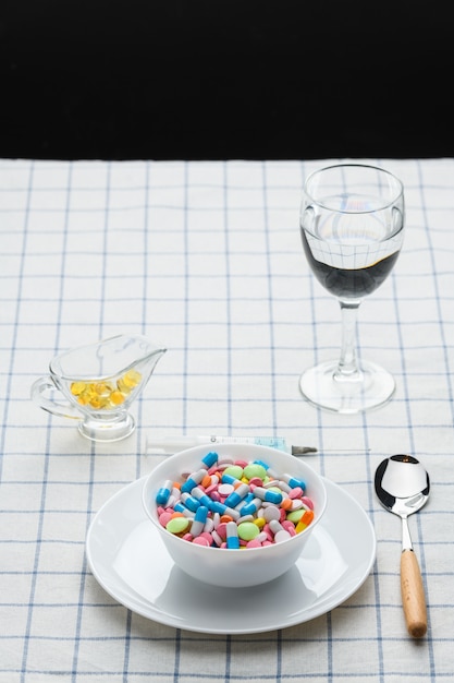 Un plato de pastillas y medicamentos sobre la mesa.