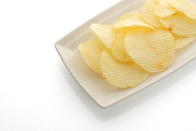 Plato de patatas fritas con volantes aislado sobre un fondo blanco.