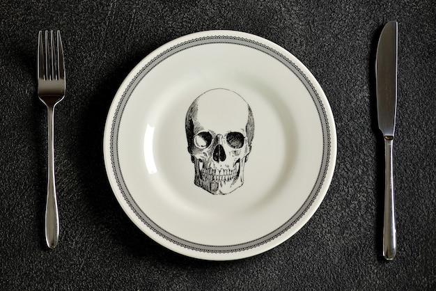 Plato con patrón de calavera, tenedor y cuchillo