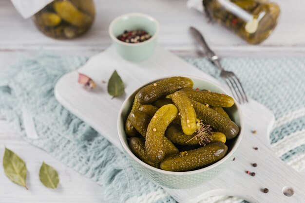 Plato de pepinillos, pepinos encurtidos sobre superficie de madera rústica blanca. Comida limpia, concepto de comida vegetariana