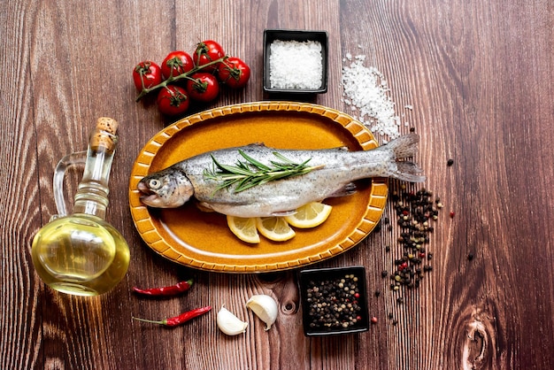 Un plato de pescado e ingredientes en una mesa de madera.