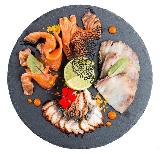 El plato de pescado Seth con pescado graso de salmón y anguila en un plato de piedra sobre fondo blanco