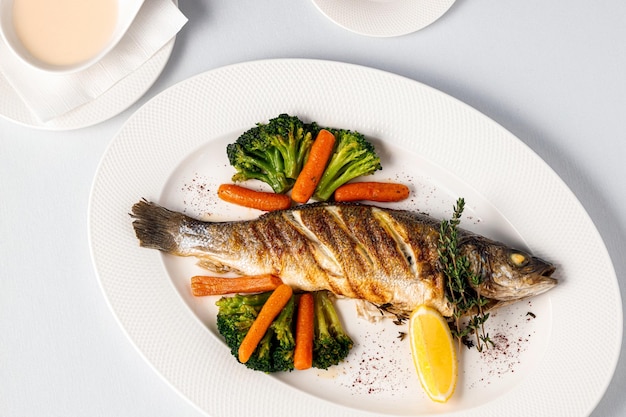 Un plato de pescado con verduras y un plato de comida.