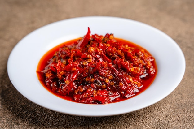 Un plato de pimientos rojos con salsa roja