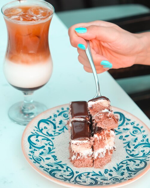 un plato con un plato de pastel y un tenedor con helado de chocolate en él