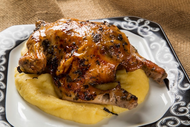 Plato de pollo con polenta en mesa de madera