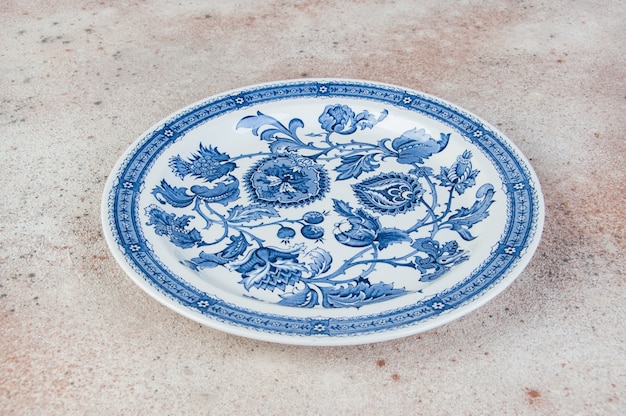 Foto plato de porcelana antigua sobre hormigón