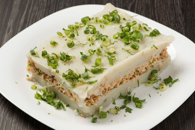 Plato con puré de papa relleno de pechuga de pollo desmenuzado.