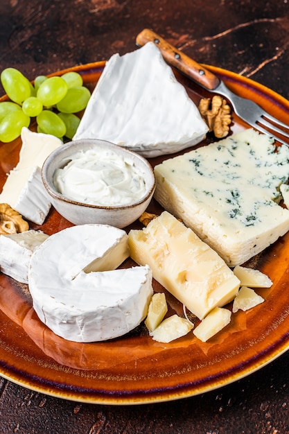 Plato de queso con Brie, Camembert, Roquefort, crema de queso azul, uva y nueces.