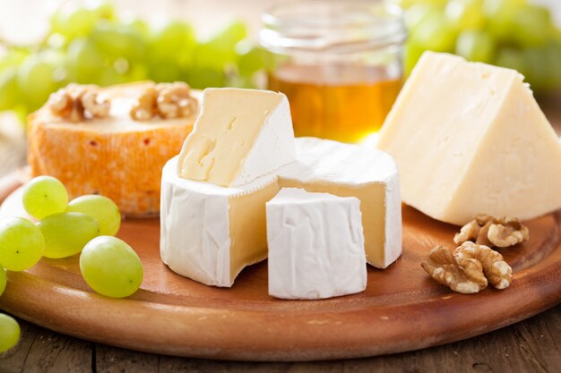 Plato de queso con camembert, queso cheddar, uvas y miel.