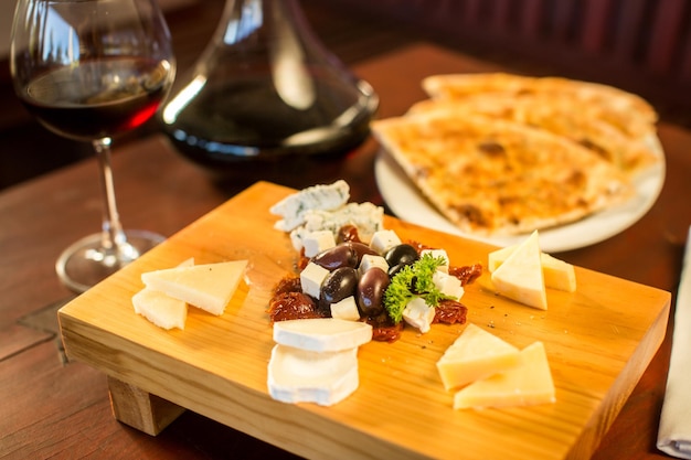 Plato de queso con una copa de vino tinto