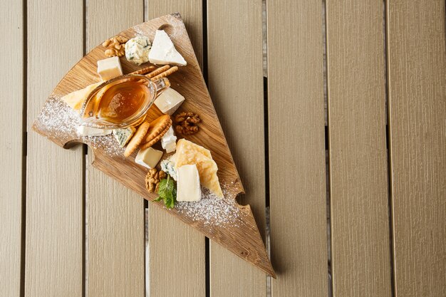 Plato de queso de degustación en un plato de madera.