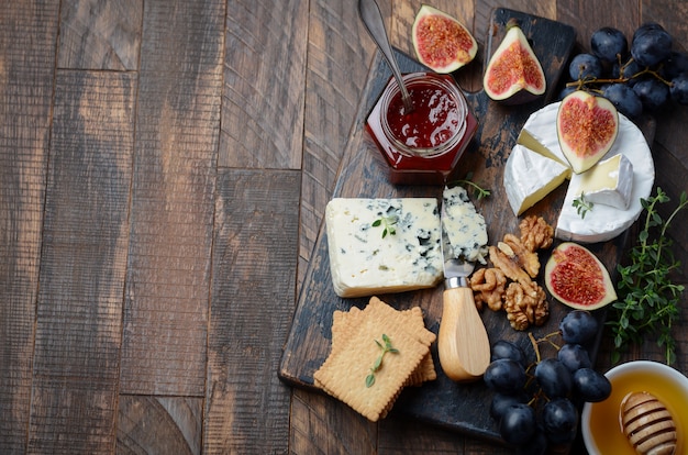 Plato de queso con frutas y nueces.