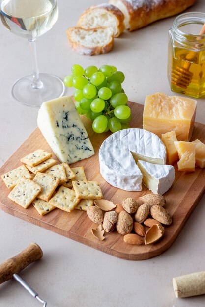 Plato de queso con galleta, almendras y uvas. Aperitivo de vino. Bocadillo de vino.