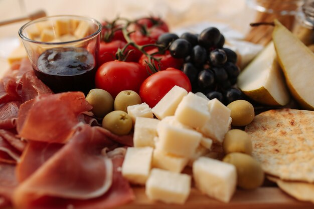 Foto plato de queso con jamón y verduras