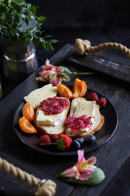 Un plato de queso y mermelada con un ramo de flores.