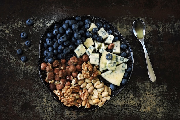 Plato con queso, nueces y arándanos.