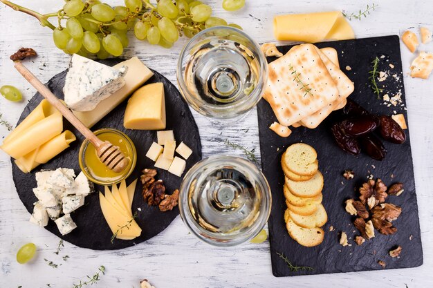 Plato de queso. Surtido de queso con nueces, pan y miel en placa de pizarra de piedra.