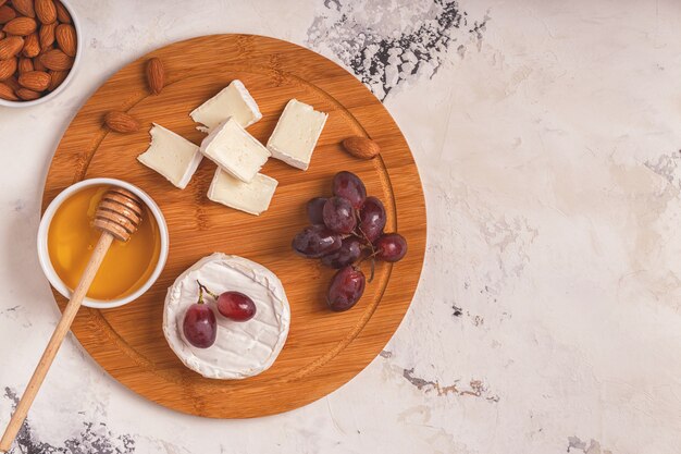 Plato con queso, uvas, nueces y miel.