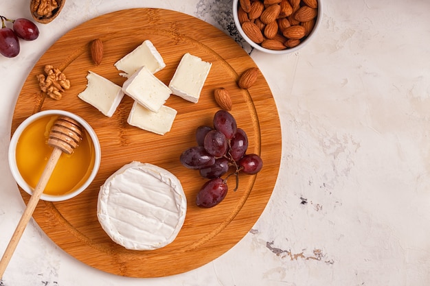 Plato con queso, uvas, nueces y miel