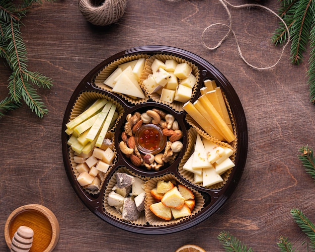 Plato de queso variado con miel sobre fondo de madera rústica Vista superior