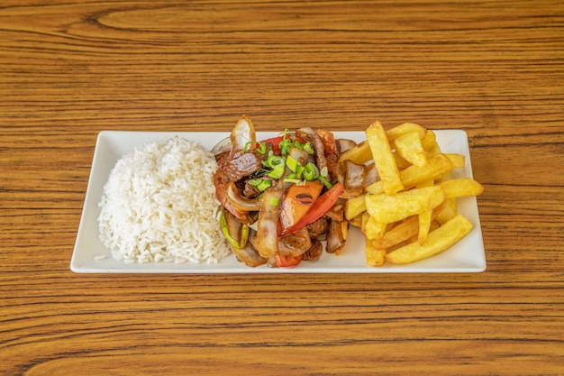 Plato de receta típica de Perú con patatas fritas caseras de lomo saltado y arroz blanco