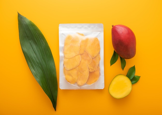 Plato redondo con pedazos de mango seco con cuchillo y frutas crudas
