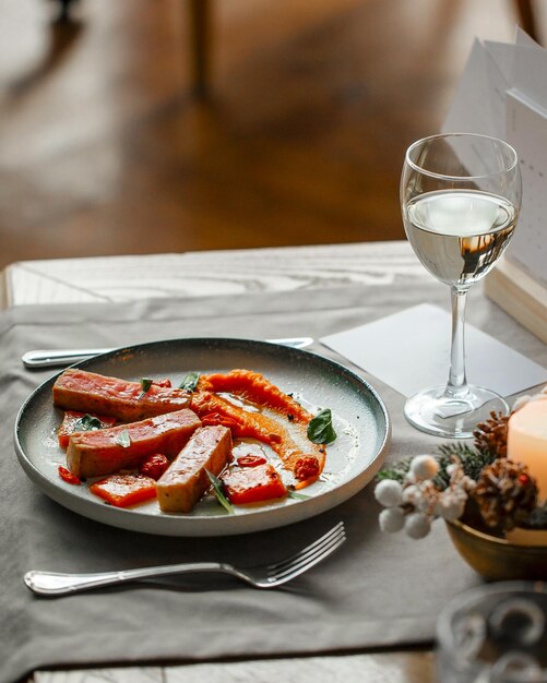 Plato de restaurante gourmet con atún y vino.