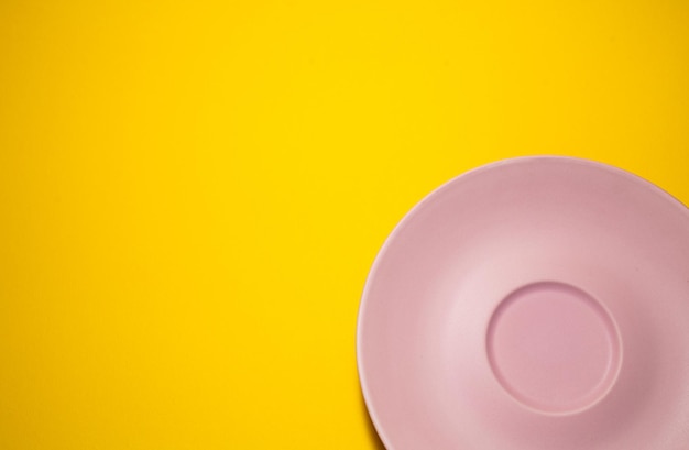 Plato rosa vacío sobre un fondo amarillo Minimalismo