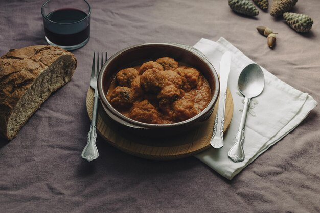 Plato rústico de albóndigas en salsa de tomate sobre un mantel