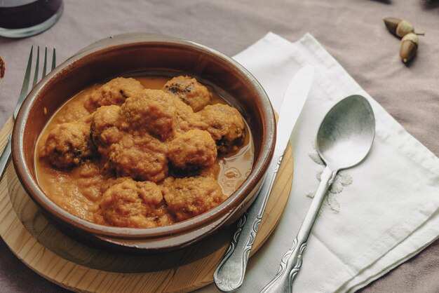 Plato rústico de albóndigas en salsa de tomate sobre un mantel