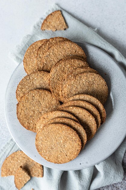 Plato con sabrosas galletas con sésamo y semillas de lino sobre fondo de piedra gris