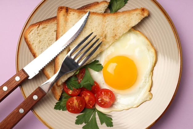 Plato de sabroso desayuno sobre fondo violeta