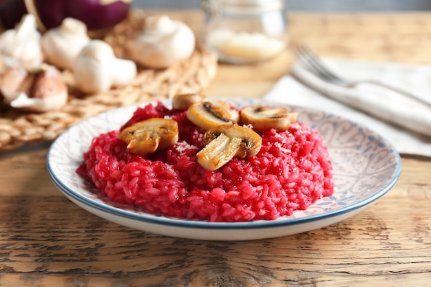 Plato de sabroso risotto de remolacha con champiñones en primer plano de la mesa