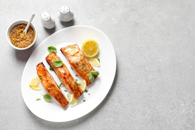 Plato con sabroso salmón cocido servido para la cena en la vista superior de la mesa