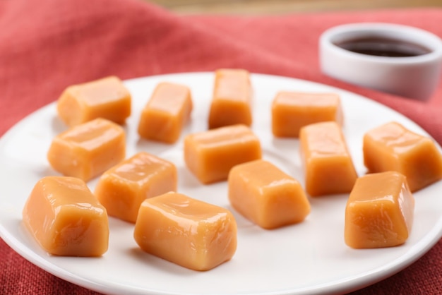 Plato con sabrosos dulces de caramelo en primer plano de la mesa