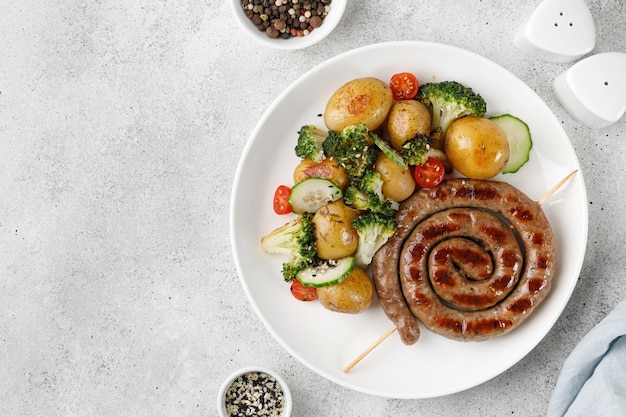 Plato con salchichas de cerdo a la parrilla y papas brócoli en plato blanco Cena almuerzo Salchicha casera