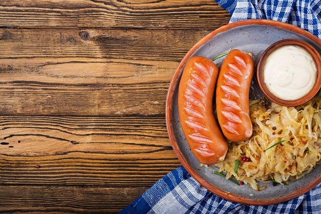 Plato de salchichas y chucrut en la mesa de madera. Menú tradicional de Oktoberfest