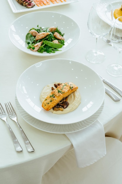 Un plato de salmón con ensalada en la mesa.