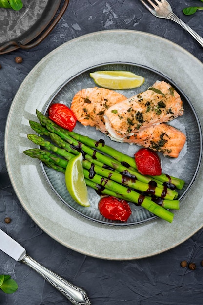 Un plato de salmón con espárragos y tomates