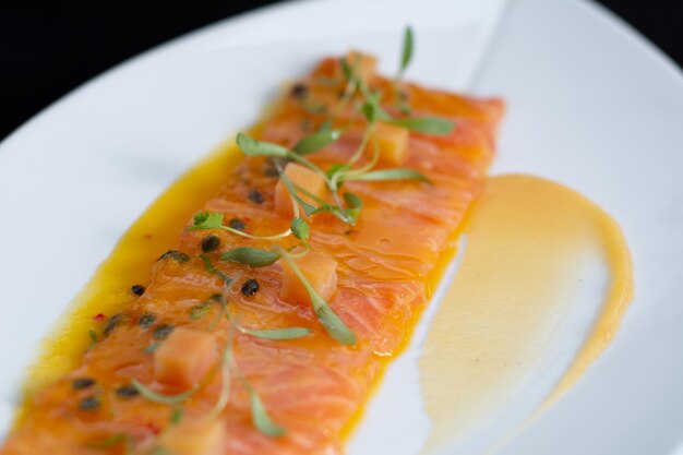 Un plato de salmón con salsa amarilla