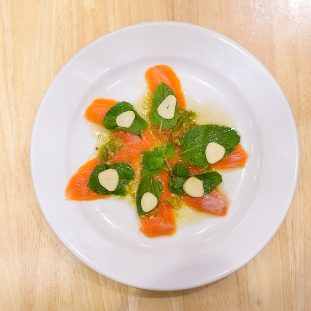 Un plato de salmón con salsa picante de mariscos en la mesa de madera