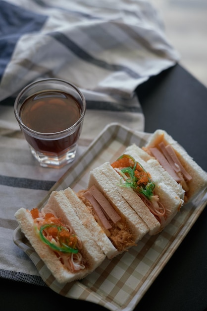 Un plato de sándwiches con una taza de café al lado.