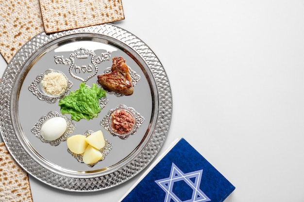 Foto plato del seder de pascua con comida tradicional sobre fondo claro