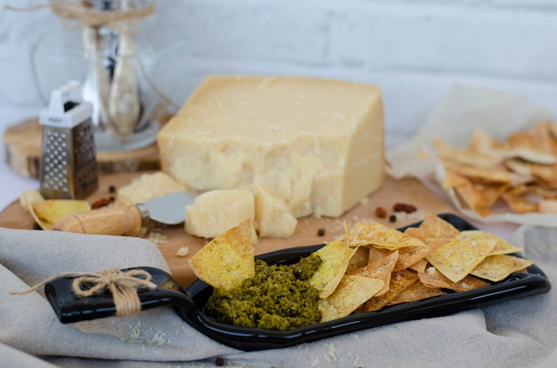 Plato para servir inusual hecho de botella con papas fritas y salsa pesto italiano y queso parmesano