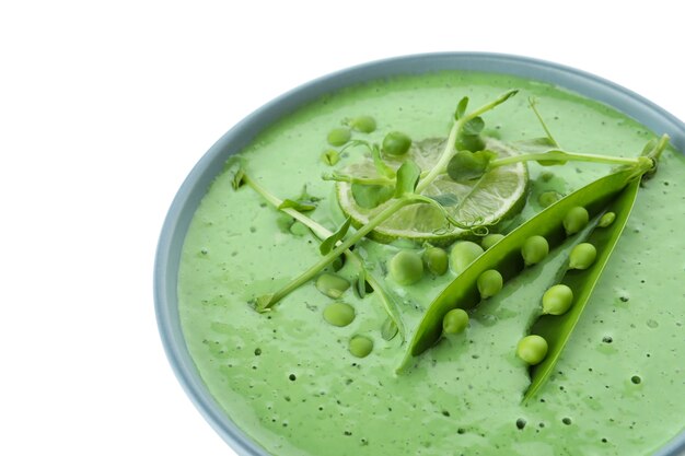 Plato de sopa de guisantes aislado sobre superficie blanca